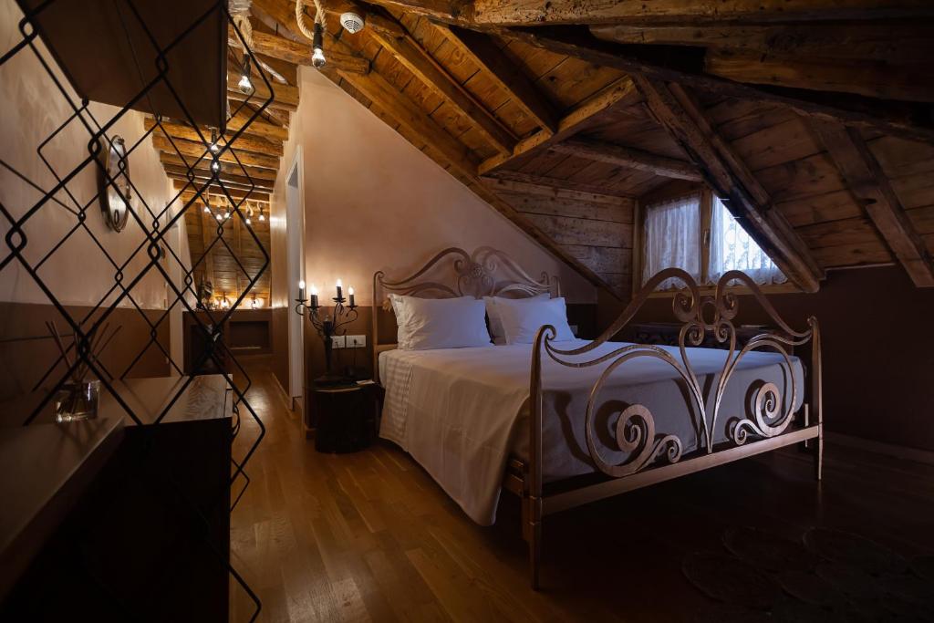 une chambre avec un lit avec des draps blancs et une fenêtre dans l'établissement Trésor Art Boutique Hotel, à Korçë