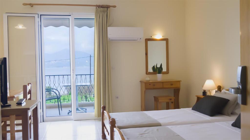 1 dormitorio con 2 camas y vistas a un balcón en Fani Hotel, en Loutra Edipsou