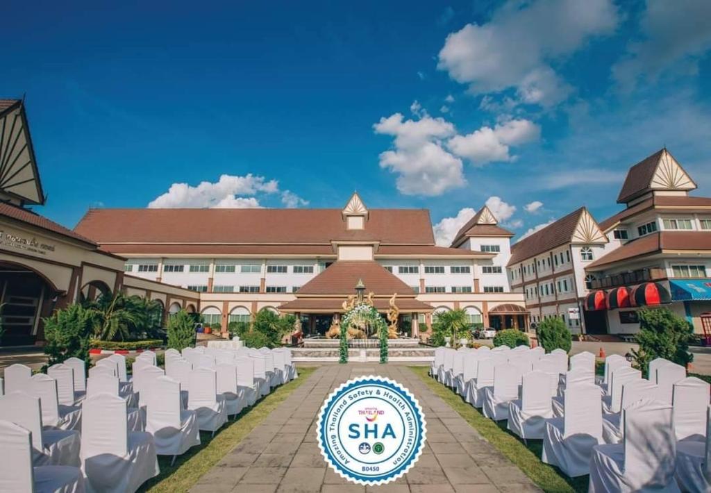 une rangée de chaises blanches devant un bâtiment dans l'établissement Major Grand Hotel, à Chum Phae