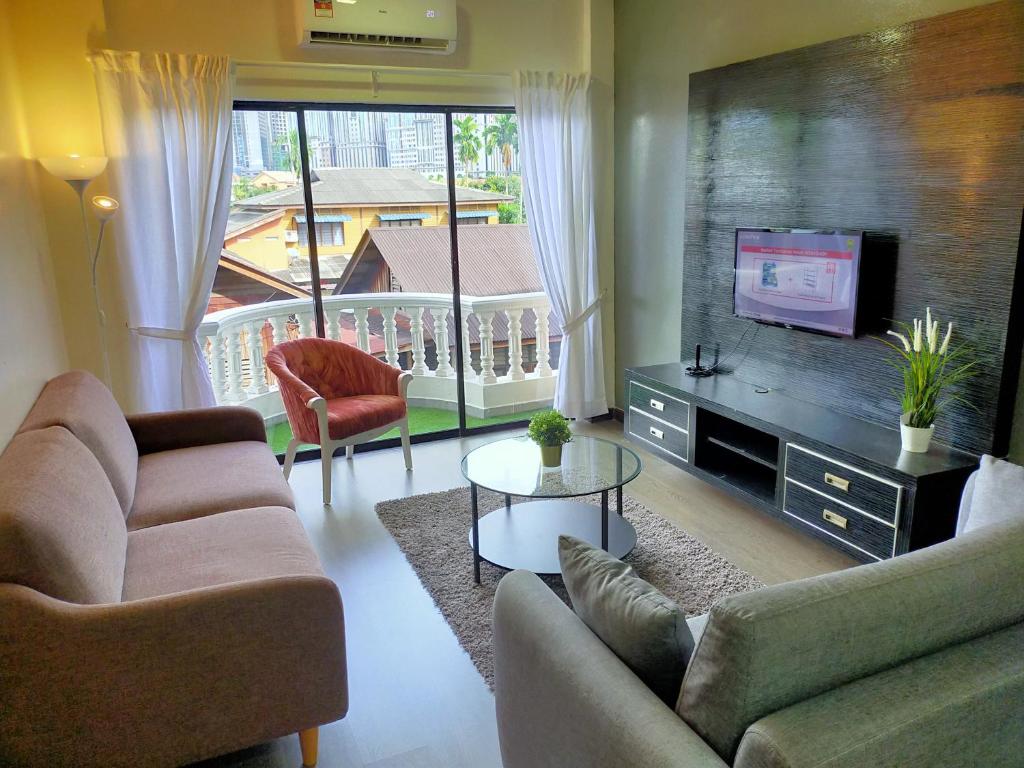 a living room with two couches and a flat screen tv at Omar's Place 3 in Kuala Lumpur