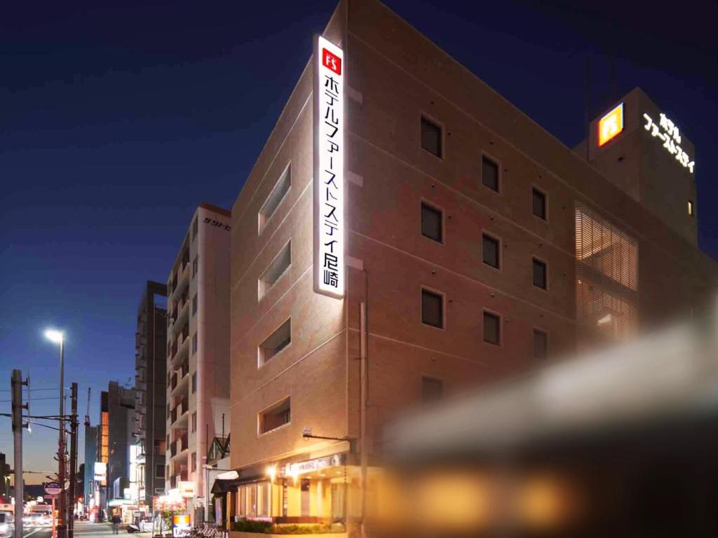 a building with a sign on the side of it at Hotel First Stay Amagasaki in Amagasaki