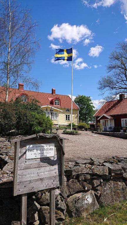 eine Flagge, die vor einem Haus über ein Schild fliegt in der Unterkunft Gällared 710 - Bed & Kitchen in Ullared