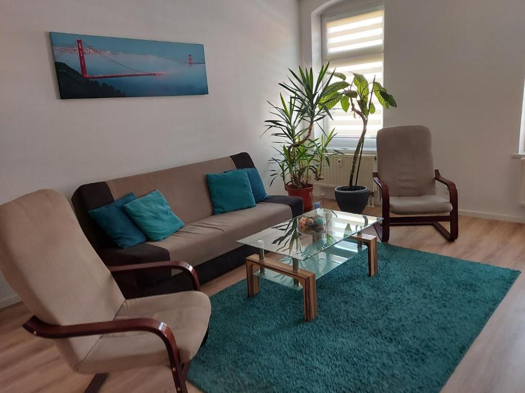 a living room with a couch and two chairs at Apartments Irena Burkert in Chemnitz