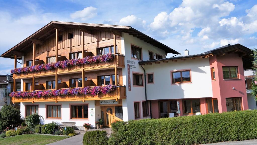 un edificio con flores a un lado. en Pension Alpina, en Reith im Alpbachtal