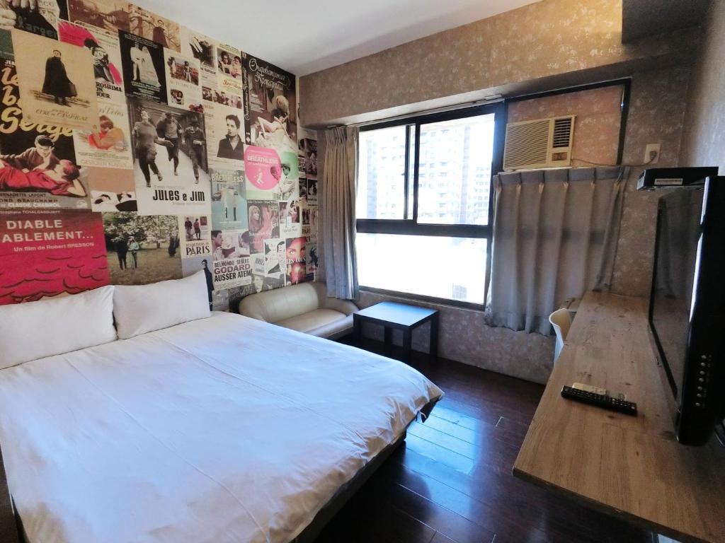 台中的住宿－Feng Chia Hygge，一间卧室配有床和带海报的墙壁