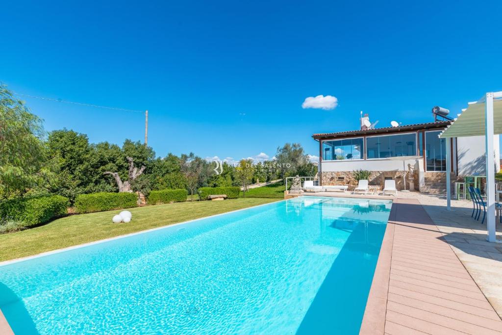 una piscina in un cortile con una casa di Villa Micasa RivedelSalento a Collepasso