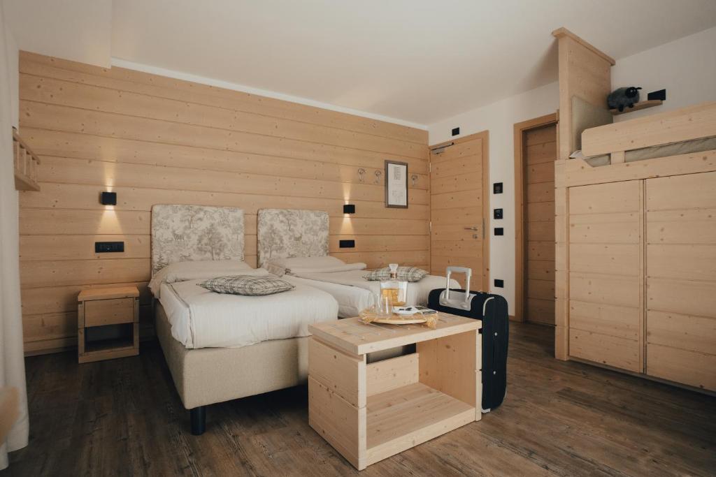 1 dormitorio grande con 1 cama y 1 mesa en Hotel Bezzi, en Passo del Tonale