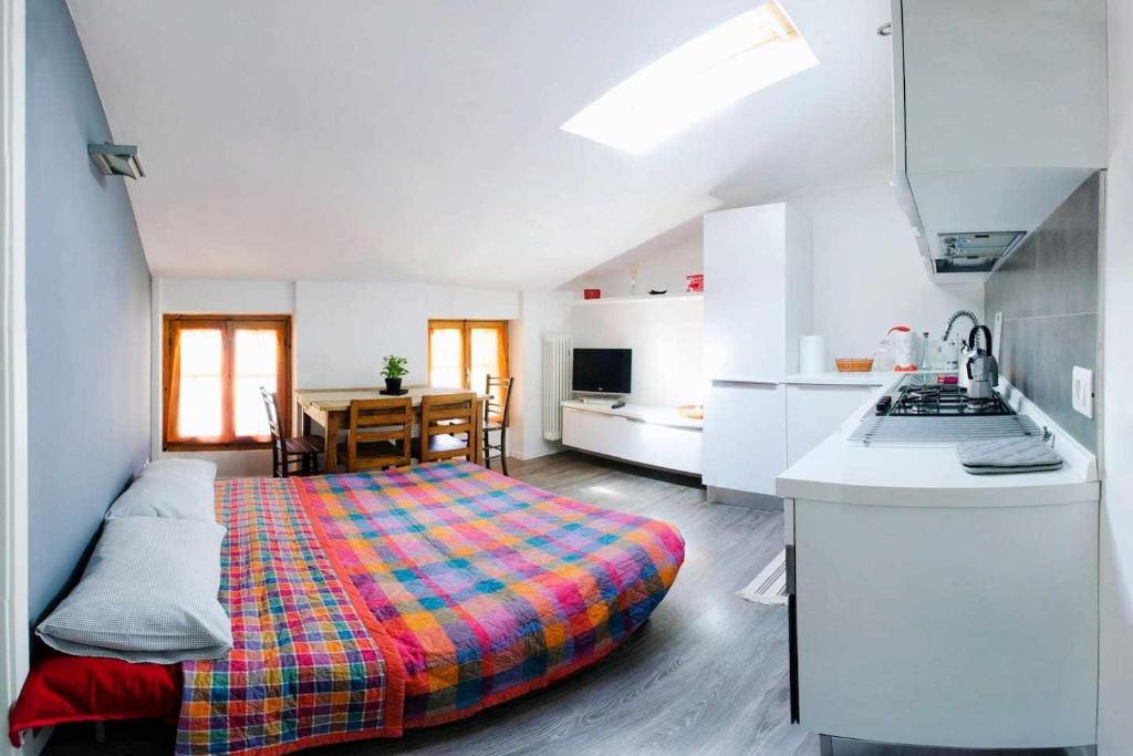 mały pokój z łóżkiem i kuchnią w obiekcie Relax Suite Holiday Apartment CIN IT02215CPAJVF w mieście Riva del Garda