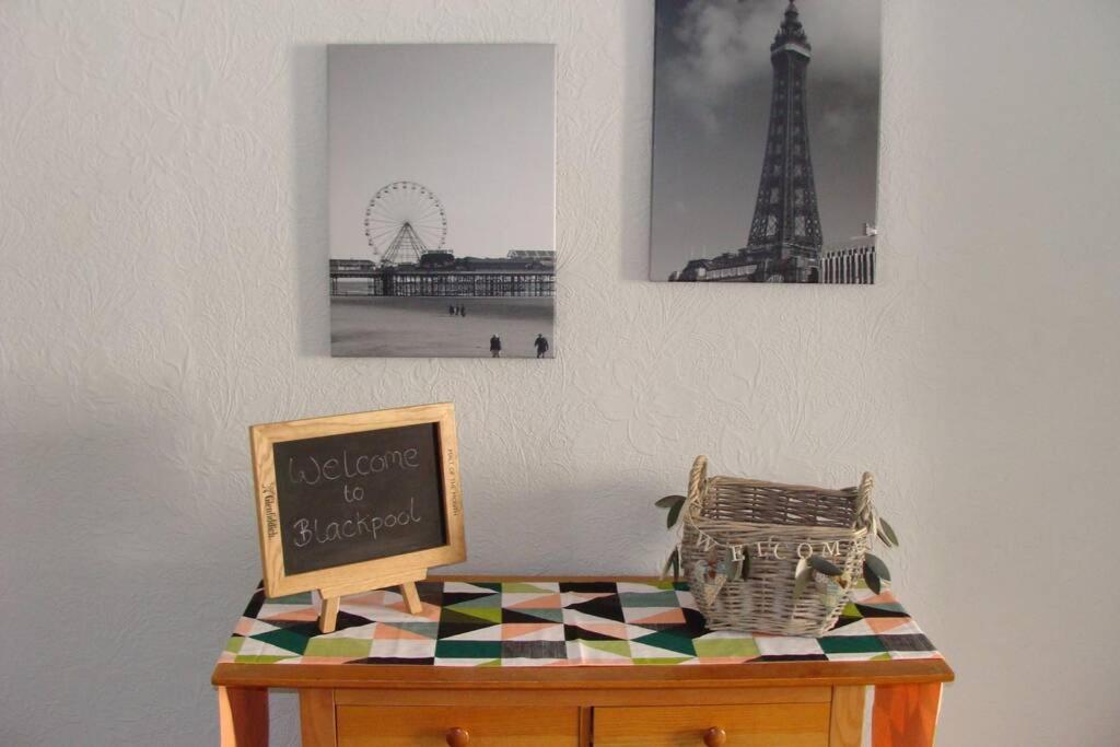 un tavolo con una lavagna sopra con un cartello di Langan's Blackpool Holiday Let a Blackpool