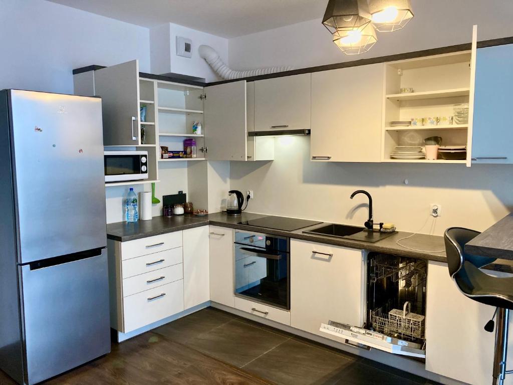 een keuken met witte kasten en een roestvrijstalen koelkast bij Modern Calm Studio, Wroclaw in Wrocław