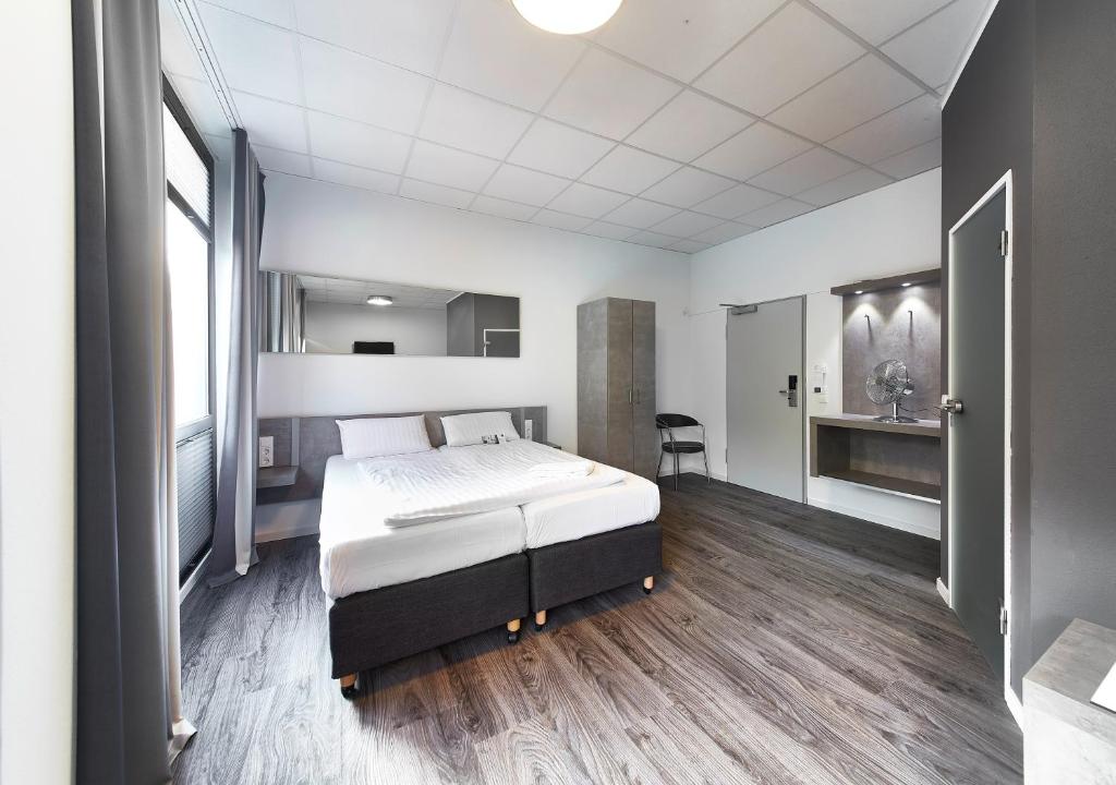 een slaapkamer met een groot bed in een kamer bij Road House Hotel in Paderborn