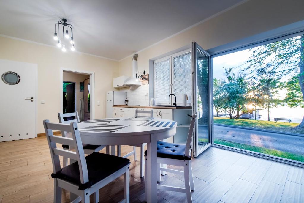 a kitchen with a table and chairs and a large window at Apartament pod Grotem z Widokiem na Jezioro, Oczy Mazur in Giżycko