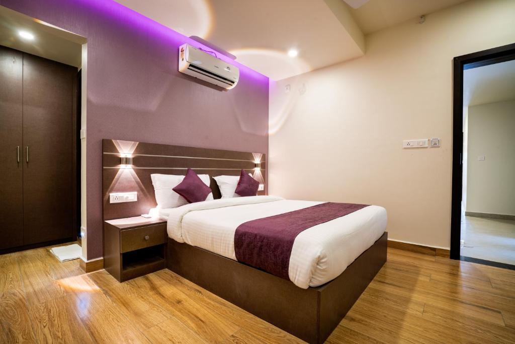 Habitación de hotel con cama con techo púrpura en Lavender Infopark Kochi en Kakkanad