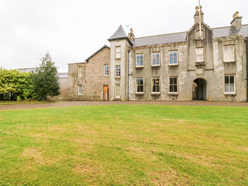 an old stone building with a large grass yard at North Wing - Pitmedden Gardens in Ellon