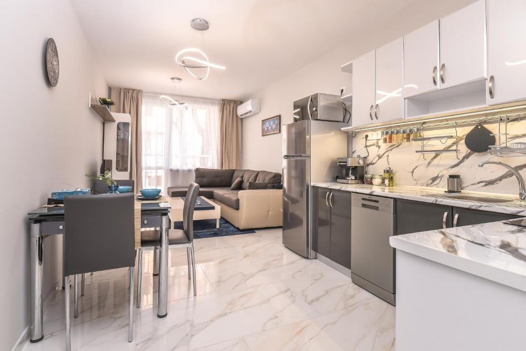 a kitchen and a living room with a couch at Stylish Residential Flat ~ with Parking & Balcony in Sofia