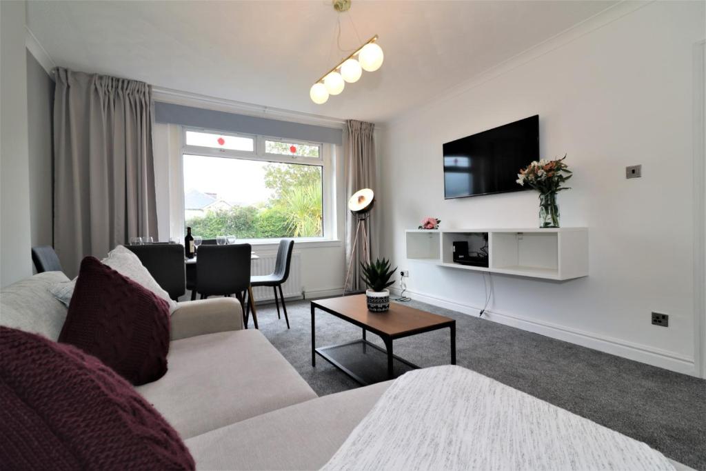ein Wohnzimmer mit einem Sofa und einem Tisch in der Unterkunft Macintosh lower in Bellshill