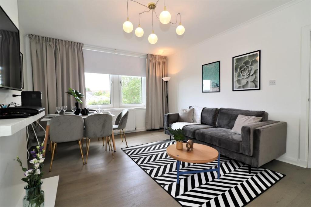 ein Wohnzimmer mit einem Sofa und einem Tisch in der Unterkunft Macintosh Upper in Bellshill