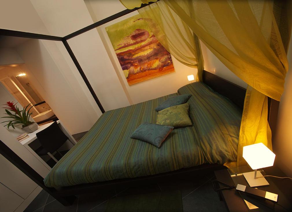 Ca' Pozzo Inn في البندقية: غرفة نوم صغيرة مع سرير مع وسادتين