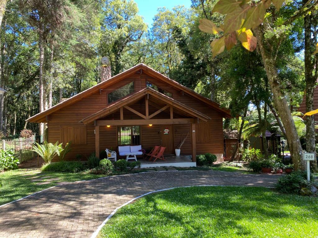 a log cabin with a porch in a yard at Casa Estilo Canadense - Canela in Canela