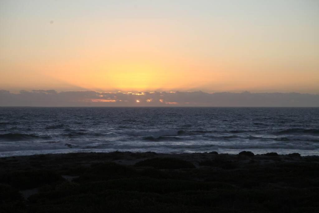 a sunset over the ocean with the sun setting at Mossel is the Gem of Yzerfontein in Yzerfontein