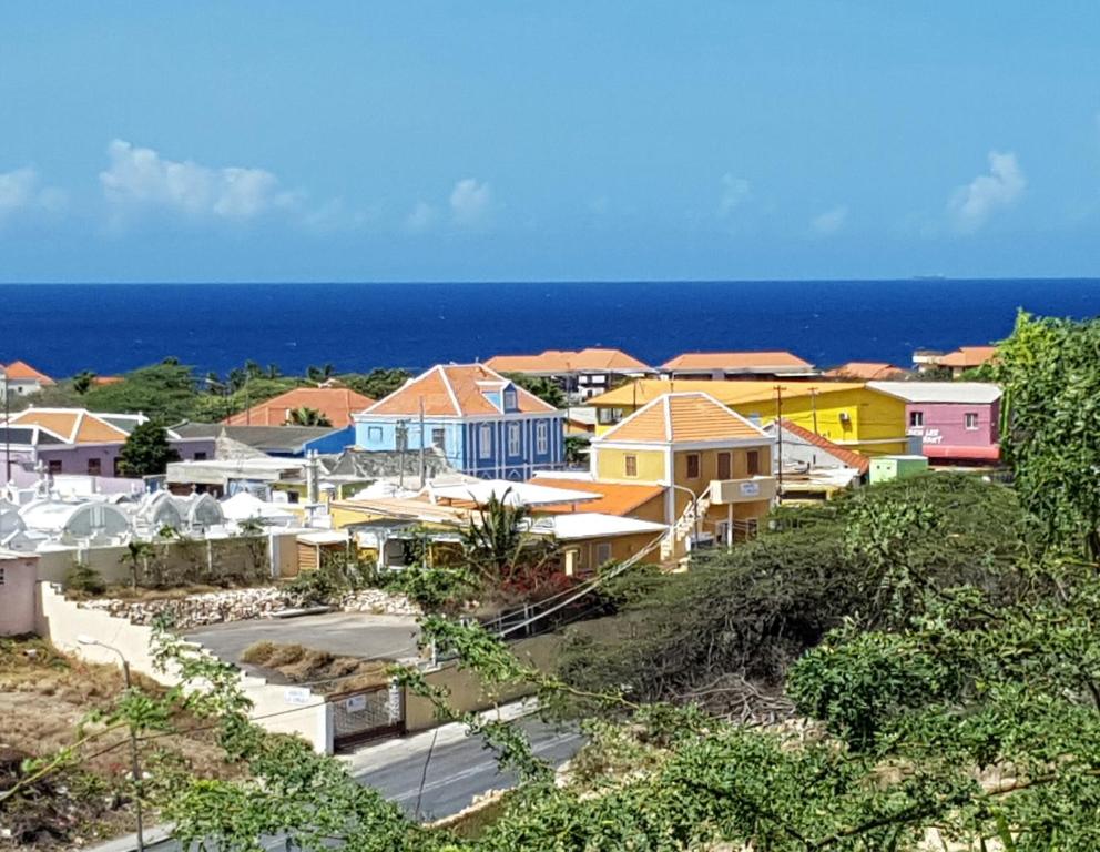 a small town with colorful houses and the ocean at La Bamba in Willemstad
