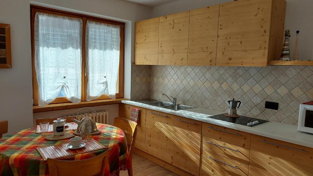 a kitchen with a table and a sink and a counter at Appartamento Elena in Bormio