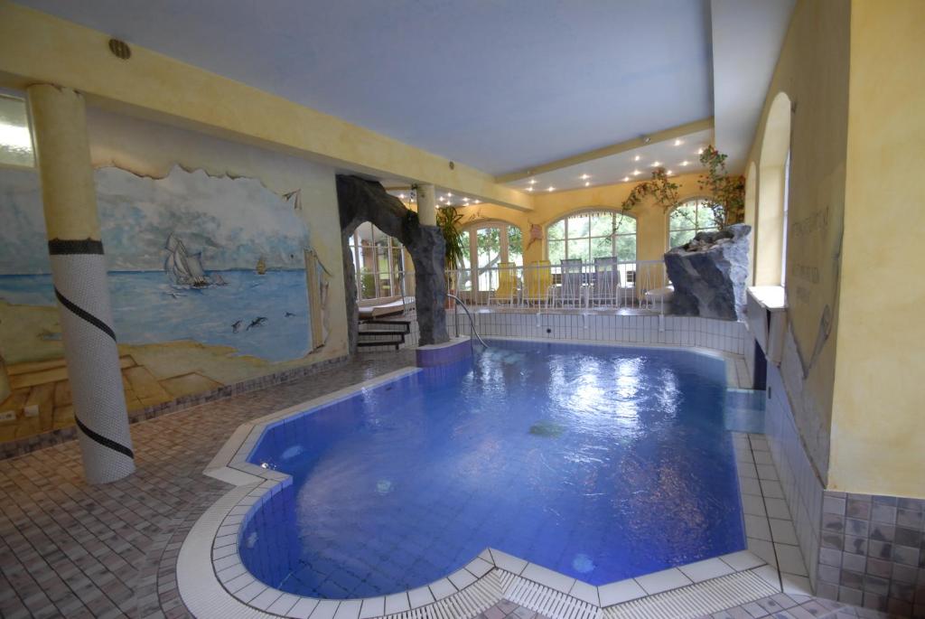 a large indoor swimming pool in a building with a large swimming pool at Pension Luzenberg in Auffach