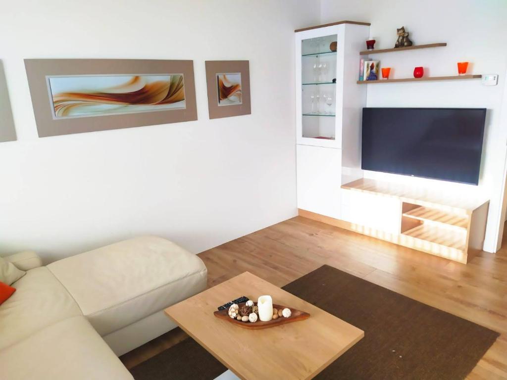 sala de estar con sofá y mesa en Alpenblick Apartment Gastein - inklusive Eintritt Alpentherme, en Bad Hofgastein