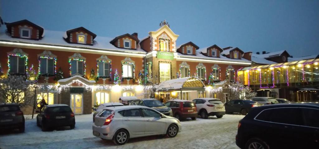 une voiture garée devant un bâtiment aux lumières de Noël dans l'établissement Hotel Staroyamskaya, à Torzhok