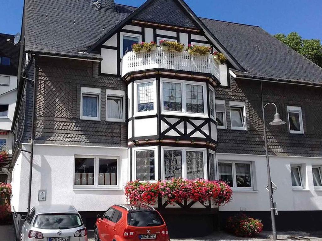 a house with two cars parked in front of it at Ferienwohnung Hacke in Schmallenberg