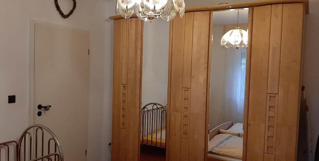 - une grande armoire en bois dans une chambre avec un lit bébé dans l'établissement Monteur-, Ferienwohnung mit Balkon in Hanau bei Frankfurt und Aschaffenburg, à Hanau