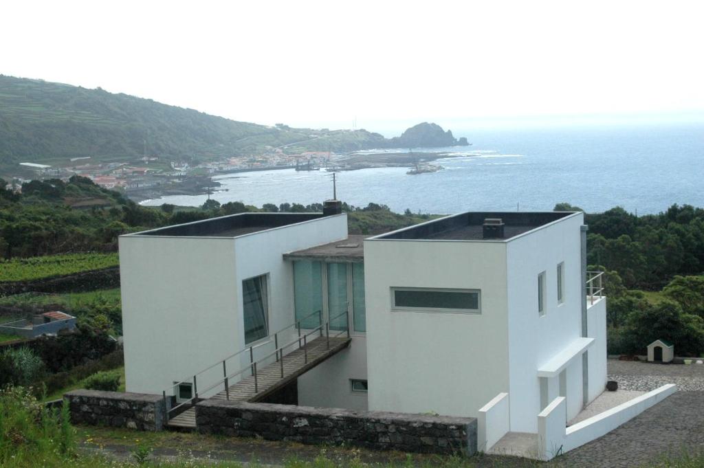 een wit huis met uitzicht op de oceaan bij Casa da Ribeira in Lajes do Pico