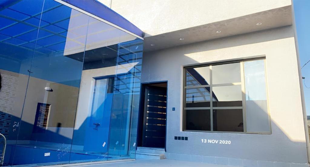 a glass facade of a building with a window at فلل ومسابح بلوسكاي الباحه-العقيق فله من ثلاث غرف نوم in Al Aqiq
