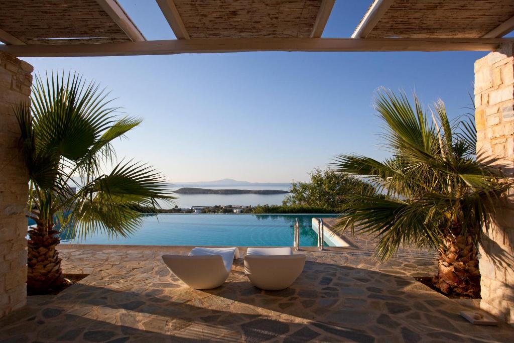 a patio with two chairs and a view of the water at Calme Boutique Hotel - Adults Only in Drios