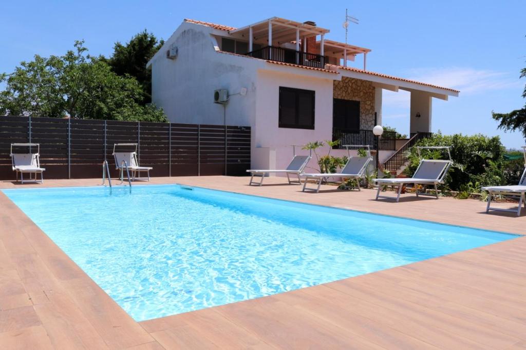 Villa con piscina frente a una casa en Villa Desìo, en Donnalucata