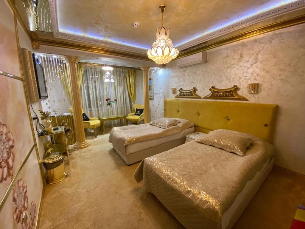 a bedroom with two beds and a chandelier at Стаи за гости Топ Старс Смолян in Smolyan