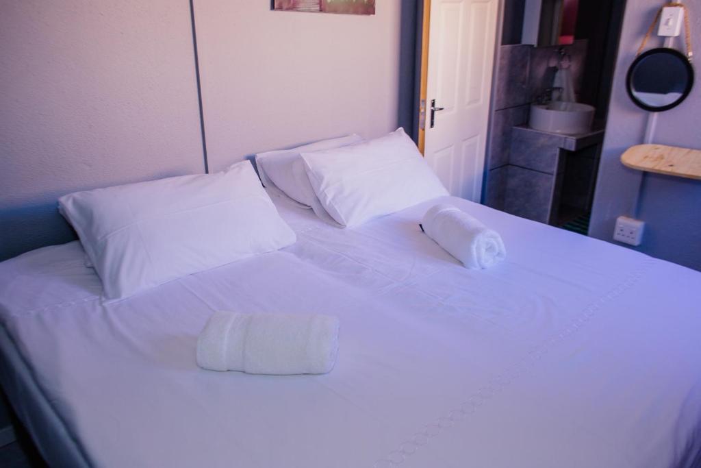 ein großes weißes Bett mit zwei Kissen darauf in der Unterkunft UrbanLife Keetmanshoop Accommodation in Keetmanshoop