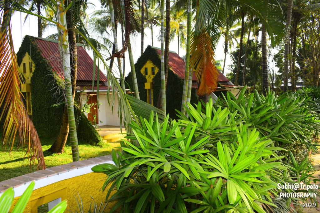 a house with a yellow sign in the middle of plants at Anandvan Holiday Homes, Wai in Wai
