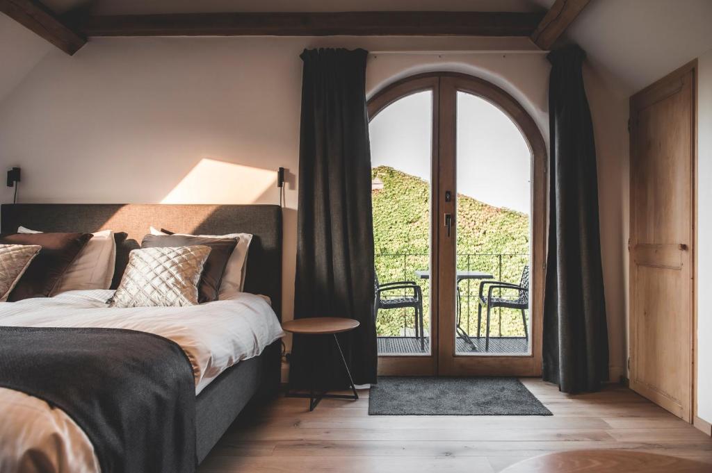 a bedroom with a bed and a door to a balcony at Ruidenberg in Kortemark