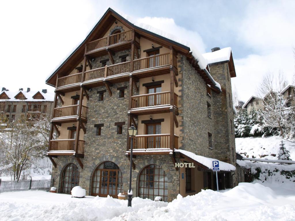 een gebouw met een balkon in de sneeuw bij Hotel Bocalé in Sallent de Gállego