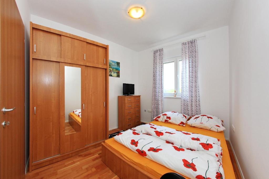 a bedroom with a bed and a large wooden cabinet at Apartment Village Nin in Nin