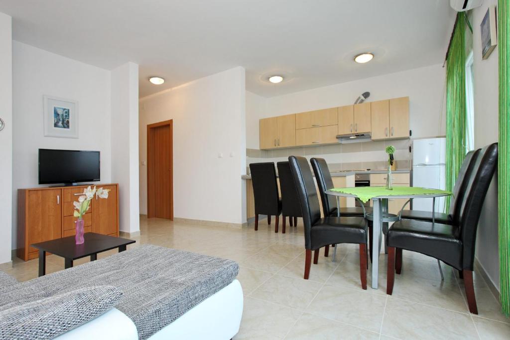 a living room with a table and chairs and a kitchen at Apartment Village Nin in Nin