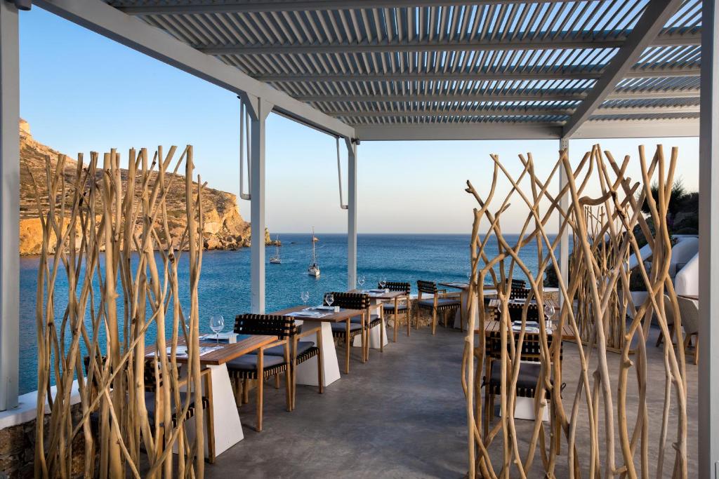 a restaurant with a view of the ocean with tables and chairs at Blue Sand Boutique Hotel & Suites in Agali