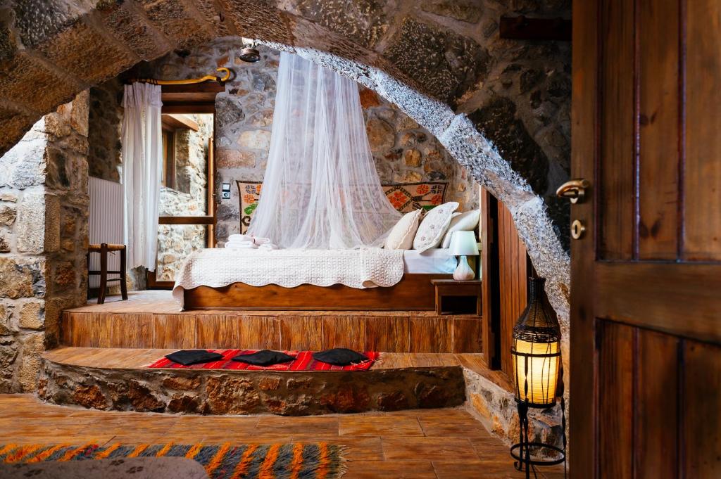a bedroom with a bed in a stone room at Vasilikata in Agios Konstantinos