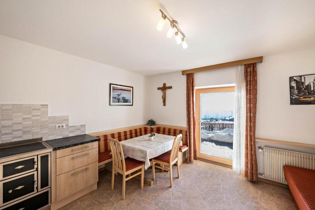 a kitchen with a table and a cross on the wall at Apartment Pustertal in Mühlbach