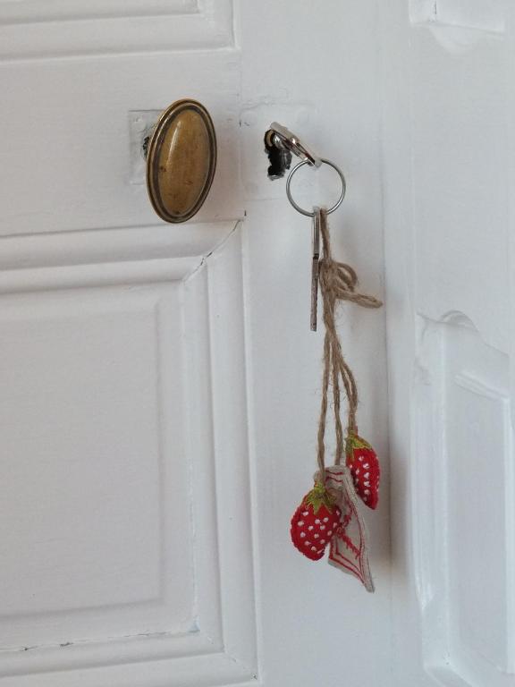 a door knob with two strawberries attached to it at La Ceriseraie in La Gorgue