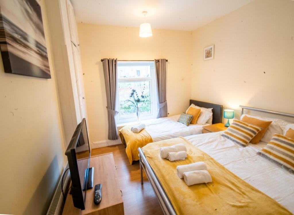 um quarto com 2 camas e uma janela em West Lea House em Chesterfield