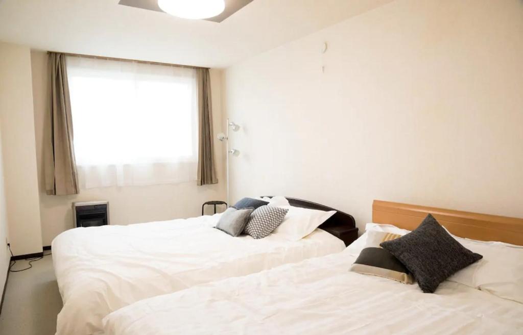 two beds sitting next to each other in a bedroom at STAY IN TOKIWA - Vacation STAY 16336v in Asahikawa