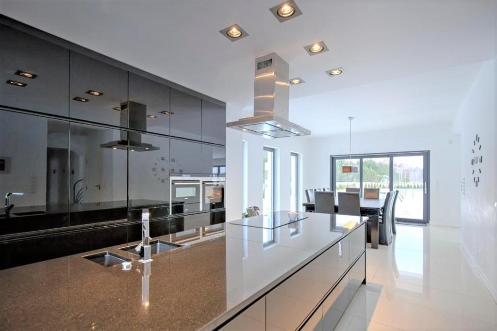 a kitchen with a white counter and a dining room at Villa Serwy in Serwy