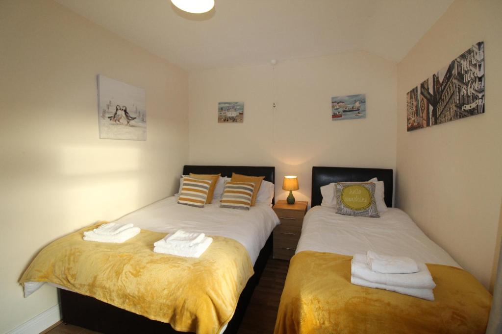 two twin beds in a room with two lamps at Loscoe House in Codnor